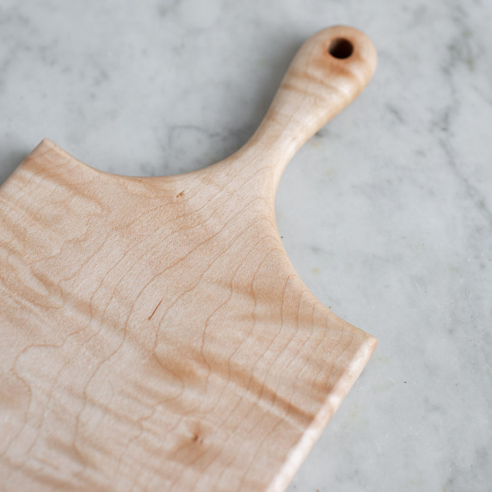 https://www.elleihome.com/cdn/shop/products/INGREDIENTS_LDN_hand_carved_wooden_curly_maple_cutting_serving_board-4_1000x1000.jpg?v=1628694667